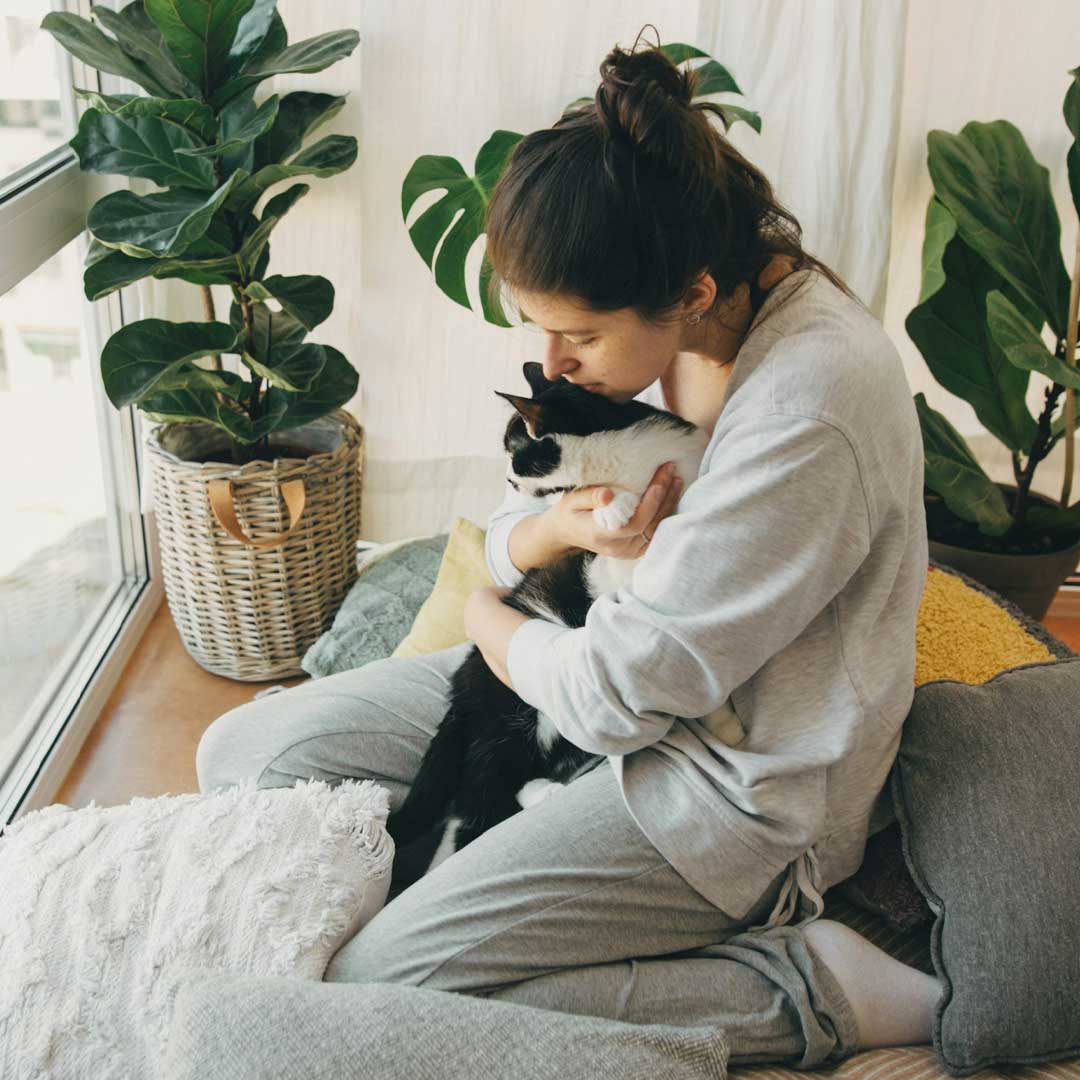 Woman kisses black and white cat